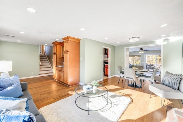 living room featuring ceiling fan and light hardwood / wood-style flooring