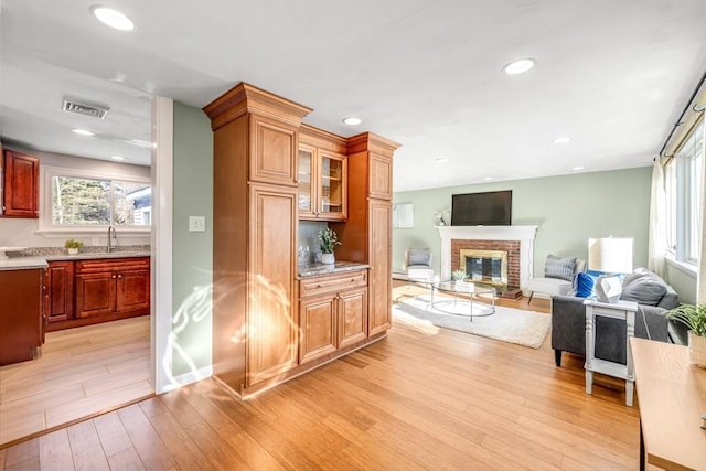 interior space featuring sink, light hardwood / wood-style flooring, and a fireplace