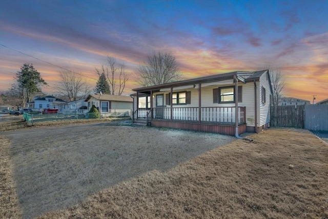 single story home with a yard and covered porch