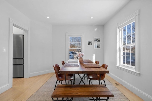 dining space featuring light wood finished floors, baseboards, visible vents, and recessed lighting