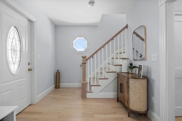 entrance foyer with baseboards, stairway, and light wood-style floors