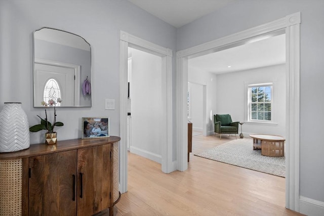 hall with light wood-type flooring and baseboards