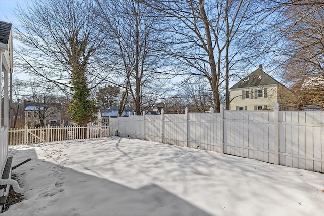 yard layered in snow featuring a fenced backyard