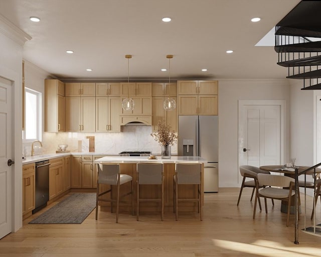 kitchen featuring a center island, stainless steel appliances, light countertops, hanging light fixtures, and ornamental molding