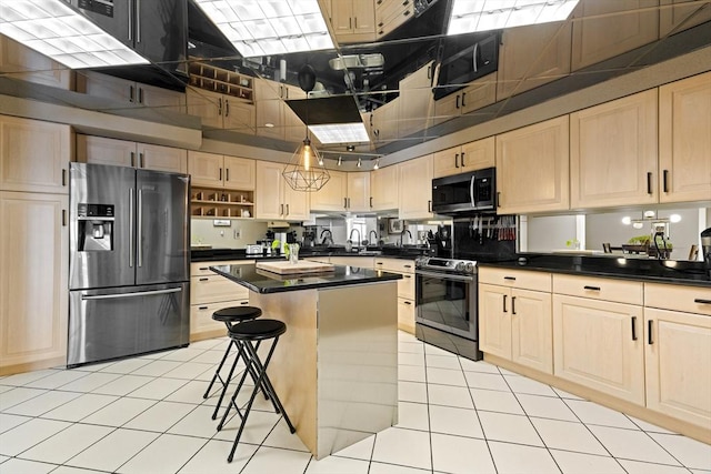 kitchen featuring dark countertops, light brown cabinets, and appliances with stainless steel finishes