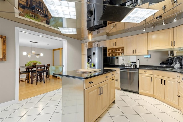 kitchen featuring a sink, dark countertops, appliances with stainless steel finishes, and light brown cabinetry