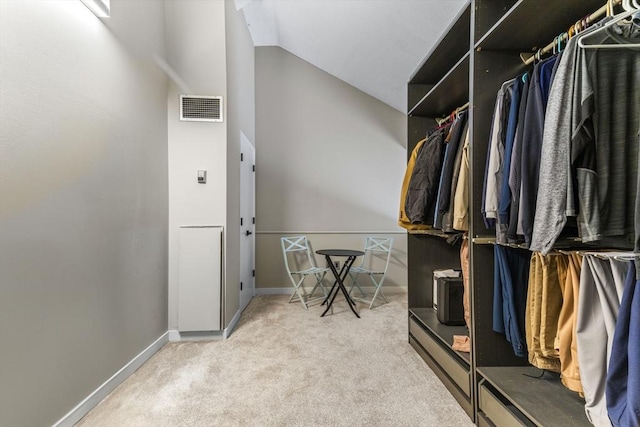 walk in closet featuring visible vents, lofted ceiling, and carpet floors