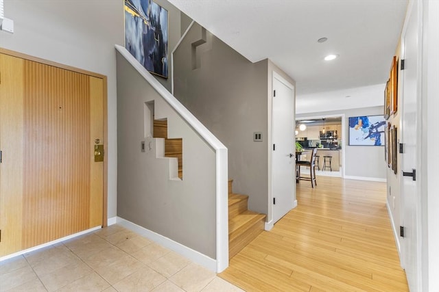 foyer featuring recessed lighting, baseboards, light wood-style flooring, and stairs