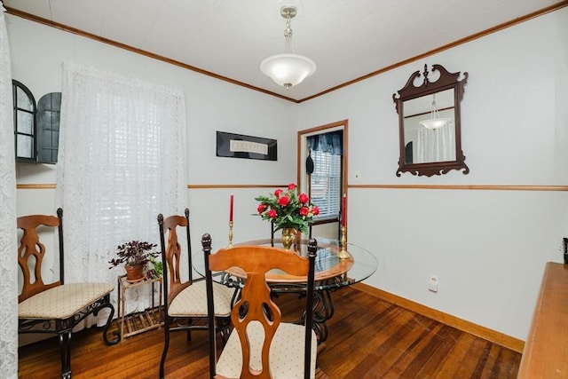 dining room with baseboards, ornamental molding, and hardwood / wood-style floors