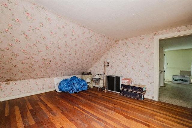 bonus room with baseboards, lofted ceiling, hardwood / wood-style floors, and wallpapered walls