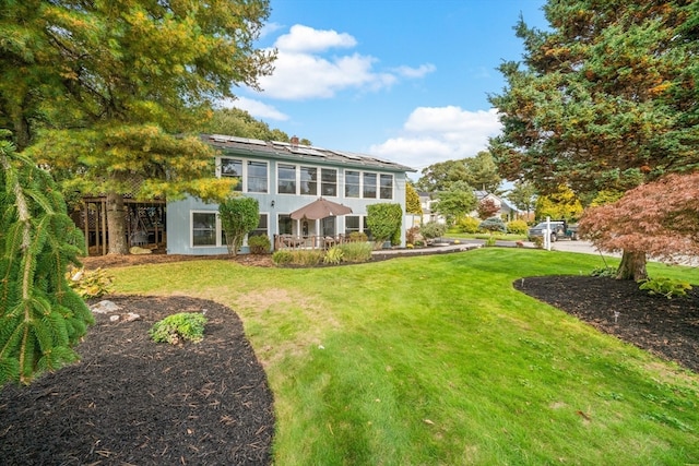 rear view of property featuring a lawn