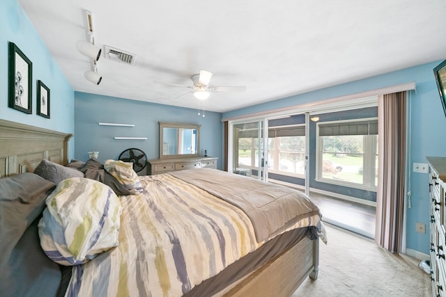 bedroom featuring light carpet, rail lighting, and ceiling fan