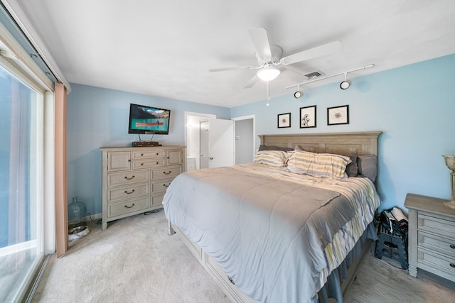 carpeted bedroom featuring rail lighting and ceiling fan