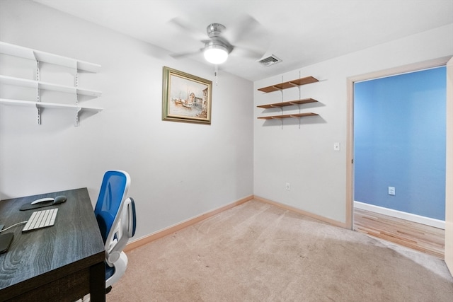 carpeted office space featuring ceiling fan