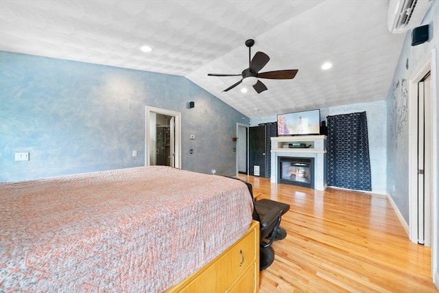 bedroom with an AC wall unit, vaulted ceiling, hardwood / wood-style flooring, and ceiling fan