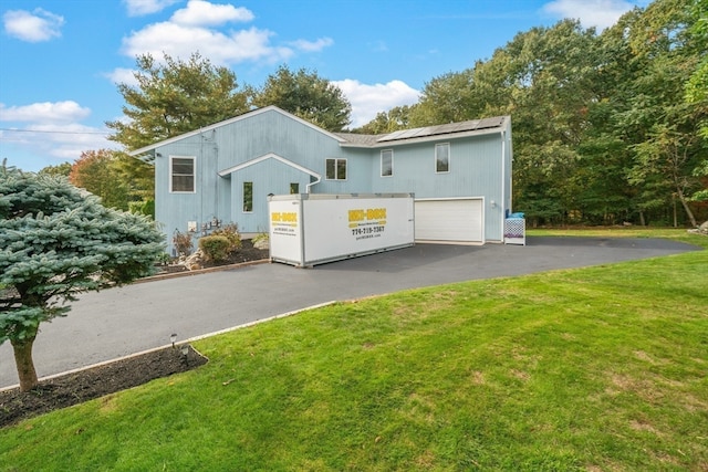 rear view of property with a yard and a garage