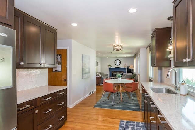146 S Main St, Natick, MA 01760 - kitchen featuring a sink, stainless steel refrigerator, tasteful backsplash, dark brown cabinets, and light wood-style flooring
