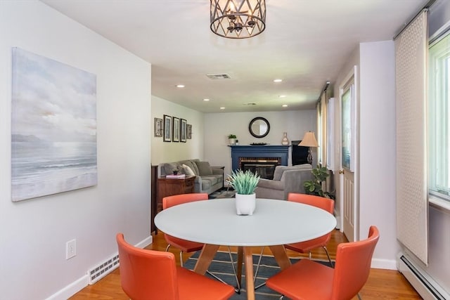 146 S Main St, Natick, MA 01760 - dining room featuring a baseboard radiator, a brick fireplace, baseboards, light wood finished floors, and recessed lighting