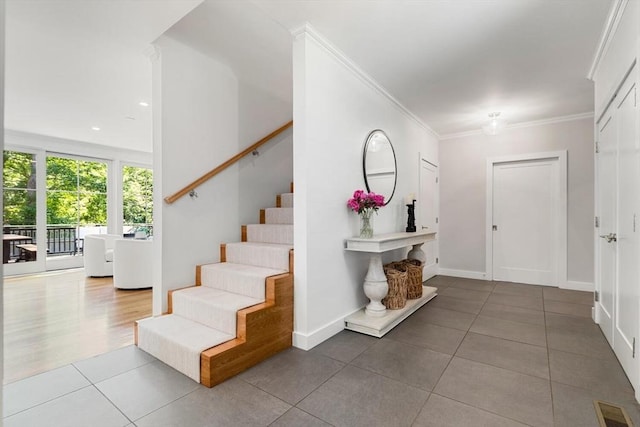 entryway with stairway, baseboards, visible vents, ornamental molding, and tile patterned floors