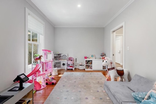 playroom featuring crown molding and wood finished floors