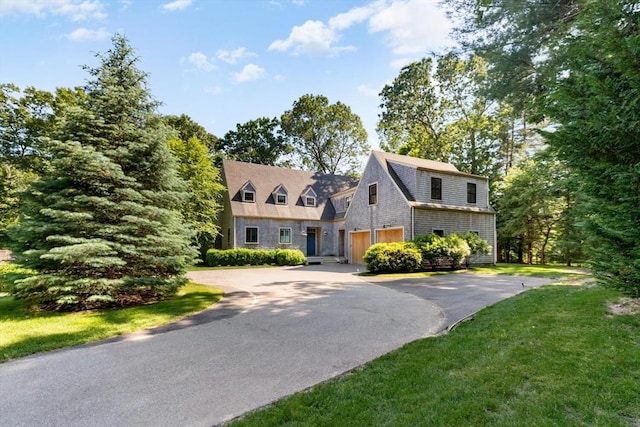 shingle-style home with a front lawn and driveway