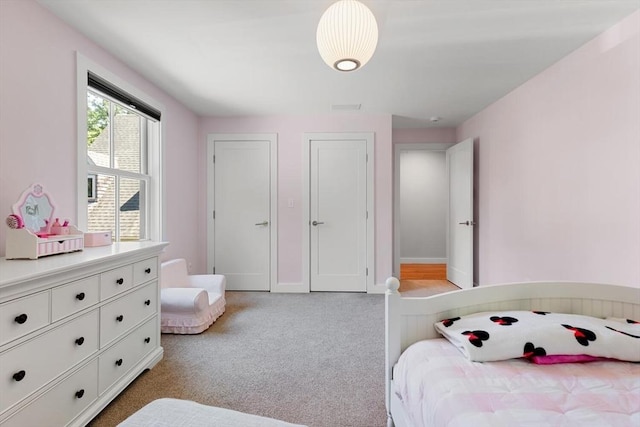 bedroom featuring baseboards and light carpet