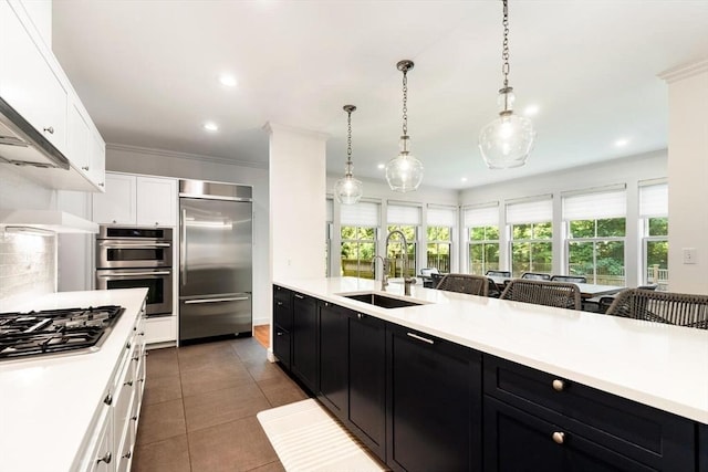 kitchen with a sink, light countertops, dark cabinets, and stainless steel appliances