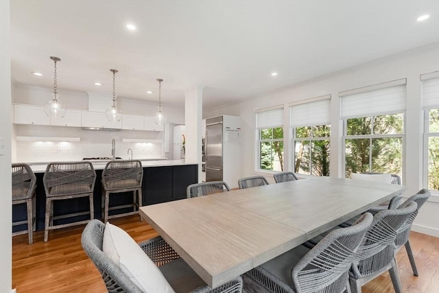 dining space featuring recessed lighting, light wood-style flooring, and crown molding