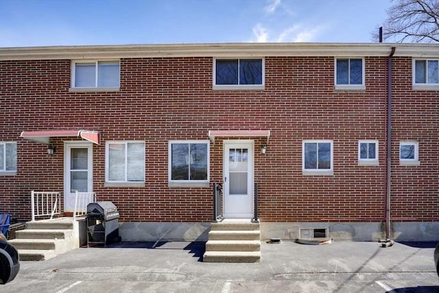 view of front facade featuring brick siding and entry steps