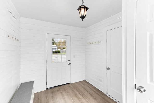 entryway with wood finished floors and wood walls