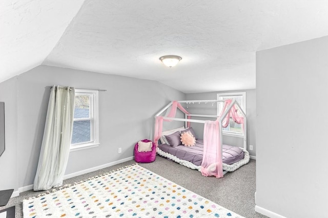 bedroom with baseboards, carpet floors, a textured ceiling, and lofted ceiling