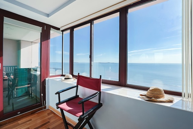 sunroom featuring a water view