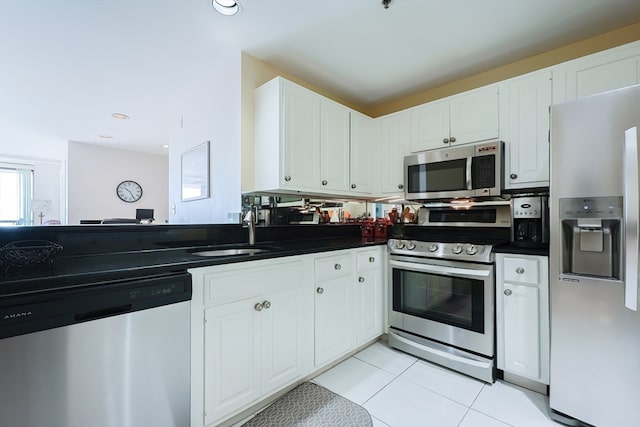 kitchen featuring sink, appliances with stainless steel finishes, white cabinetry, and light tile patterned floors