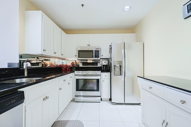 kitchen with white appliances, light tile patterned floors, white cabinetry, and sink