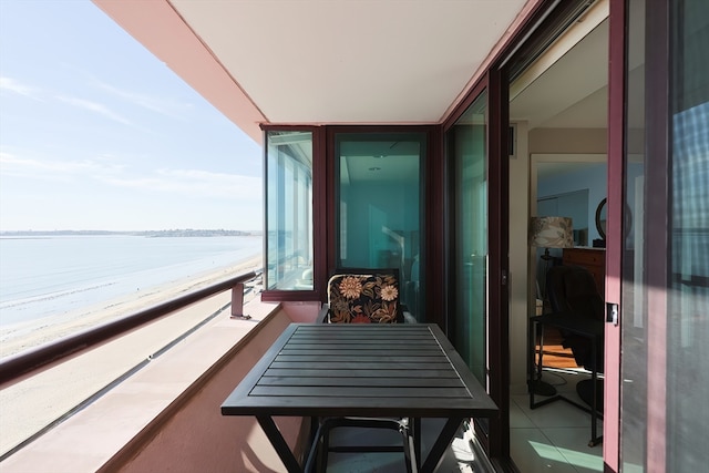 balcony featuring a view of the beach and a water view