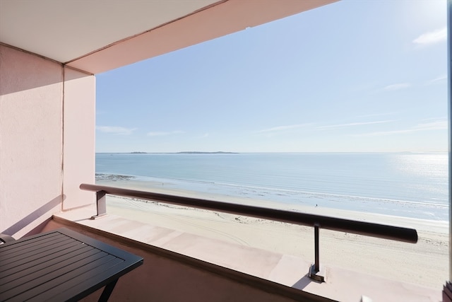 balcony featuring a water view and a view of the beach