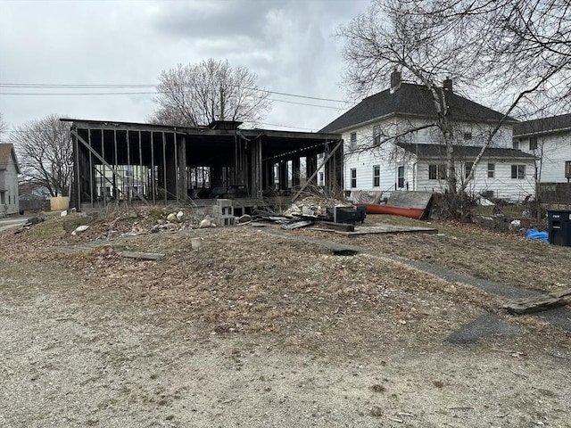 rear view of property featuring a chimney