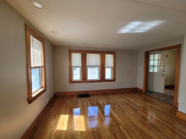 unfurnished room featuring a textured ceiling and hardwood / wood-style floors