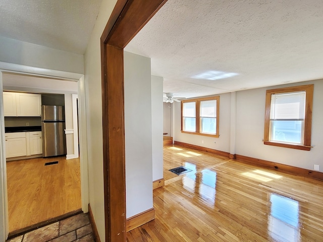 interior space featuring a wealth of natural light, a textured ceiling, and light hardwood / wood-style flooring