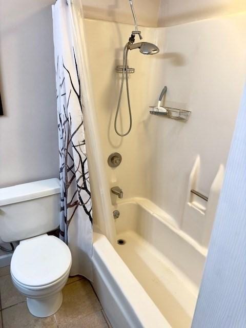 bathroom featuring tile patterned flooring, shower / bath combo, and toilet