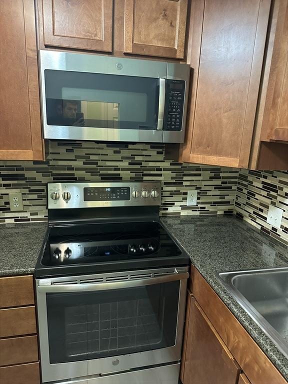 kitchen with a sink, stainless steel appliances, and backsplash