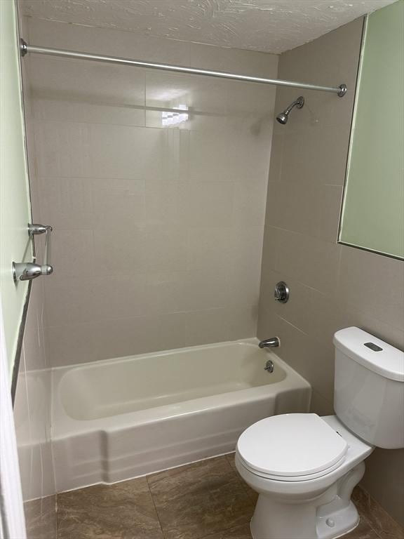 bathroom featuring a textured ceiling, shower / bathtub combination, and toilet