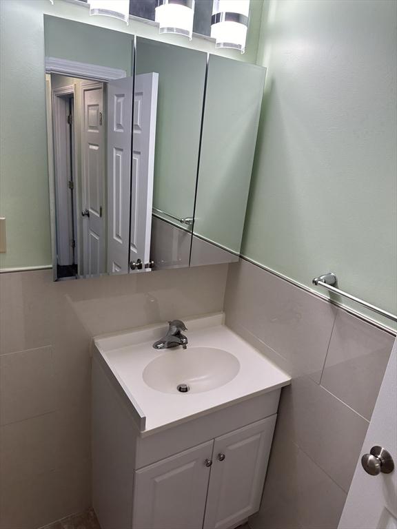 bathroom with tile walls and vanity