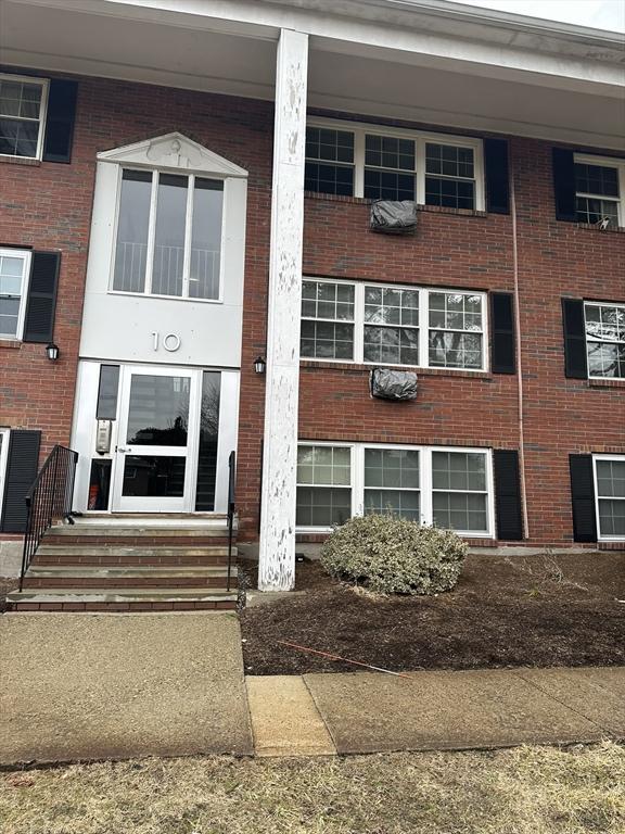 entrance to property featuring brick siding