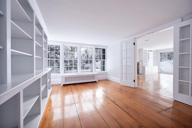 unfurnished room with ornamental molding, hardwood / wood-style flooring, french doors, and radiator