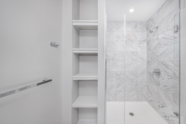 bathroom featuring a shower stall and a spacious closet