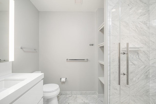 full bathroom featuring a tile shower, marble finish floor, vanity, and toilet