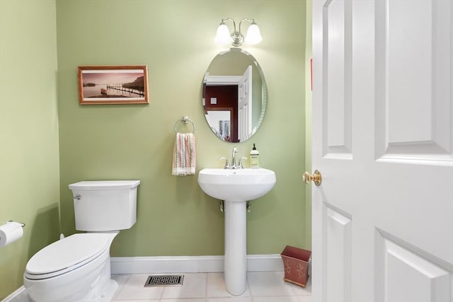 half bathroom featuring baseboards, toilet, and tile patterned flooring