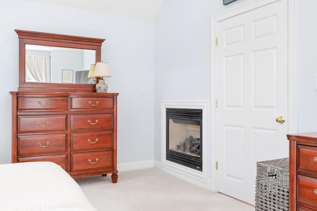 bedroom with light colored carpet and baseboards