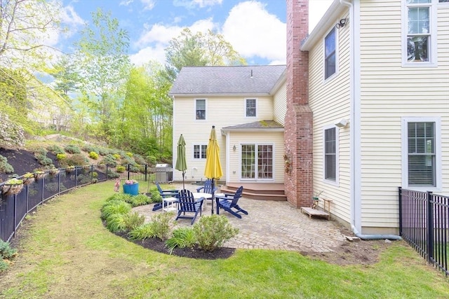 rear view of house with a patio area, a chimney, and entry steps